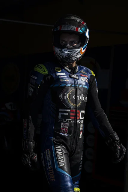Ritratto di un pilota con casco e tuta, tra luce e ombra
